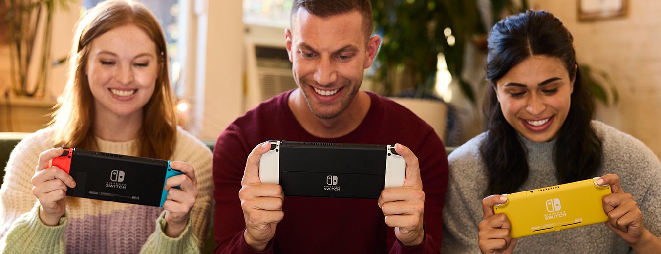 Three people playing with the three current models of Nintendo Switch